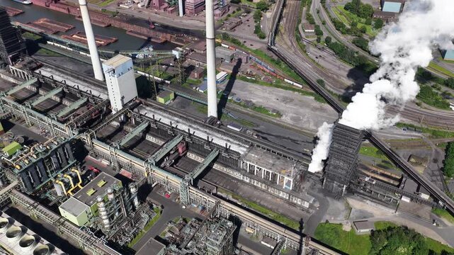 Aerial drone view of Kokerei Schwelgern in Duisburg, showing coke ovens, coal processing, chimneys and steel industry infrastructure.