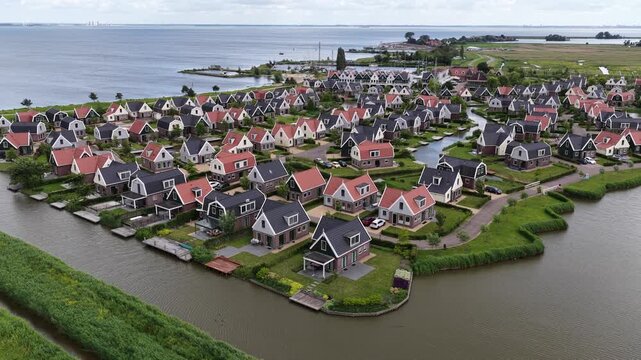 Aerial drone view of a holiday park beside the Markermeer in Uitdam, showing waterfront bungalows, apartments, marina and recreational facilities.
