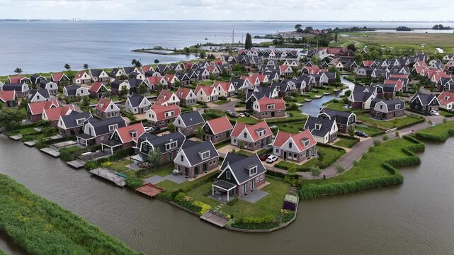 Aerial drone view of a holiday park beside the Markermeer in Uitdam, showing waterfront bungalows, apartments, marina and recreational facilities.