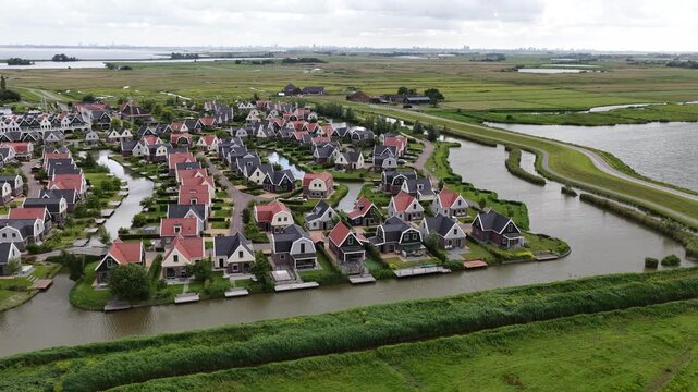 Aerial drone view of a holiday park beside the Markermeer in Uitdam, showing waterfront bungalows, apartments, marina and recreational facilities.