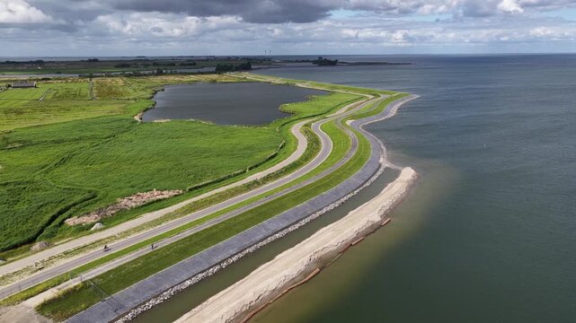 Aerial perspective showcasing the impressive coastal protection with dike reinforcement and modern flood defenses, highlighting the engineered shoreline designed to manage rising sea levels