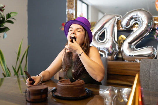 Woman celebrating 42nd birthday enjoying chocolate cake