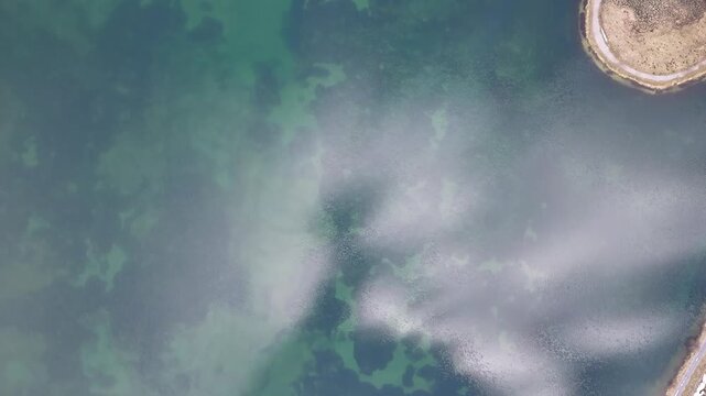 Aerial view of Obersee near N&auml;fels, Glarus, Switzerland, shoreline, clear alpine water, cloud reflections and mountain lake scenery.