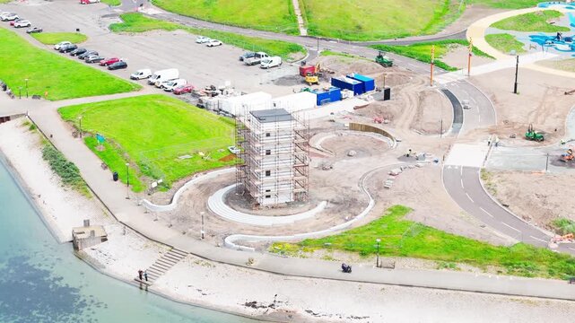 Historic coastal tower surrounded by scaffolding during restoration work. Filmed on the waterfront in Irvine, North Ayrshire, Scotland, aerial view