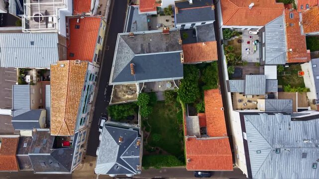 Aerial view moving over traditional houses with red tile roofs in a French coastal town, Sables d&rsquo;Olonne