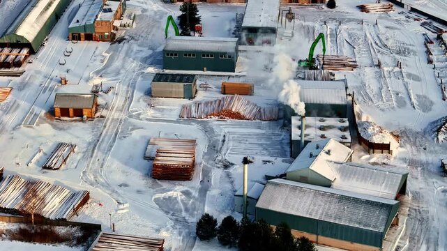 Aerial view of snowy sawmill and timber yard in Latvia