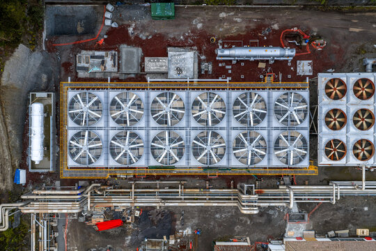 Aerial view of Ribeira Grande Geothermal Power Station with large industrial cooling fans, complex piping systems, and surrounding ground infrastructure in Ribeira Grande, Acores, Portugal.