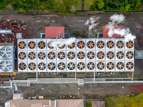 Aerial view of the Ribeira Grande Geothermal Power Station featuring rows of large industrial cooling fans emitting steam in Ribeira Grande, Acores, Portugal.
