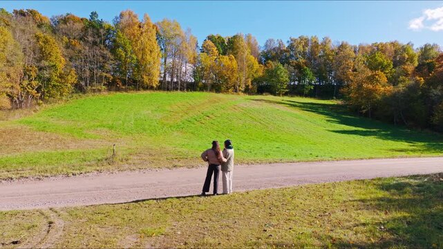Two women observe the autumn landscape in Embute parish South Kurzeme