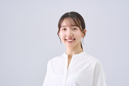 Young Japanese Woman Smiling in Casual White Top, Studio Portrait