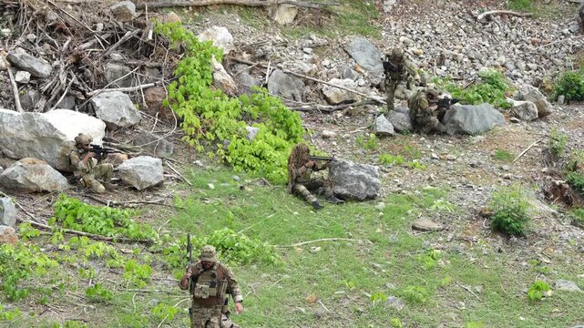 Soldiers in camouflage executing strategic movements in a scenic outdoor environment