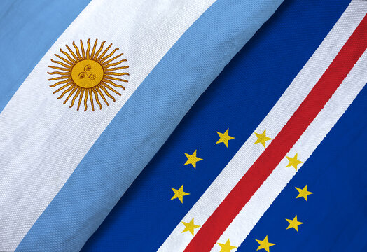 High-angle macro shot of the textile national flags of Argentina and Cape Verde overlapping to symbolize sports rivalry or diplomacy.