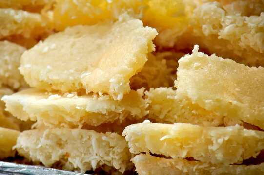 Cocada - Traditional Brazilian coconut candy pieces piled on a tray close up.
