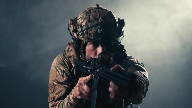 Combat soldier in camouflage uniform aiming a modern assault rifle. Concept armed forces, tactical operations and security.
