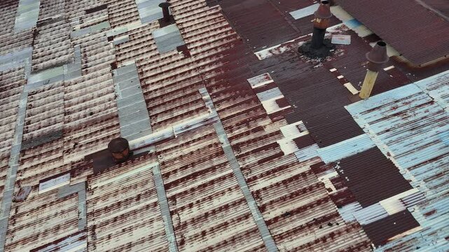 A close-up aerial view showing the factory&rsquo;s rusted corrugated metal roof with several rusted smokestacks.