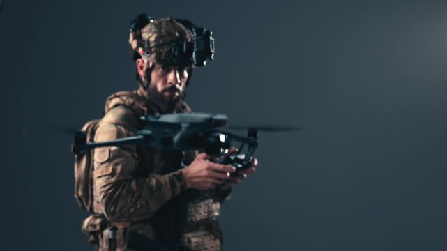 Soldier in tactical camouflage uniform operating a drone control system. Concept military technology, surveillance operations and security.

