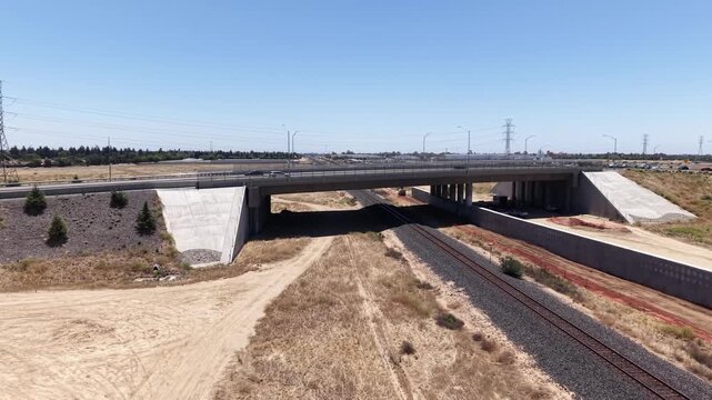 Panning Aerial Drone Shot Right to Left Over California High Speed Rail Construction Site With Train Track and Freeway Overpass