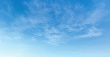 Clear blue sky with wispy, delicate clouds drifting gently © lovelyday12