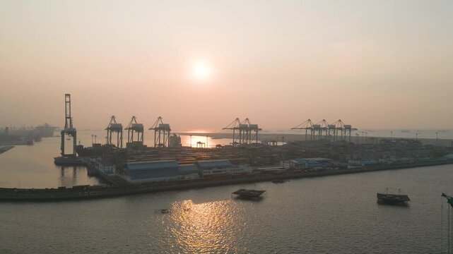 Industrial Shipping Terminal and Cargo Cranes at Golden Hour Sunset