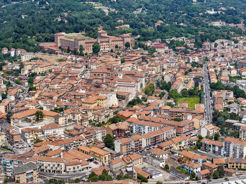 Aerial view of the historic Moncalieri Castle overlooking the dense urban landscape with terracotta rooftops, narrow streets, and surrounding green hills in Moncalieri, Piedmont, Italy.