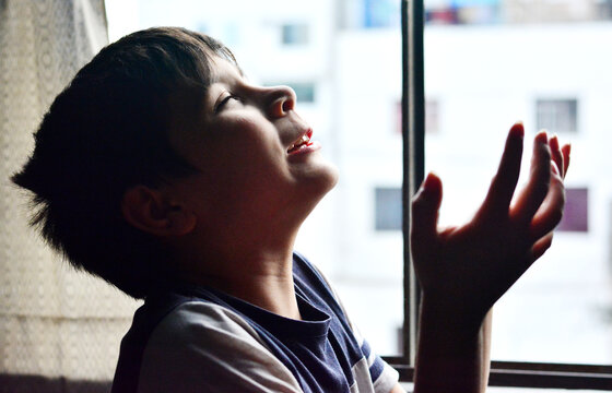 Expressive portrait of a boy with pleading and suffering expressions.