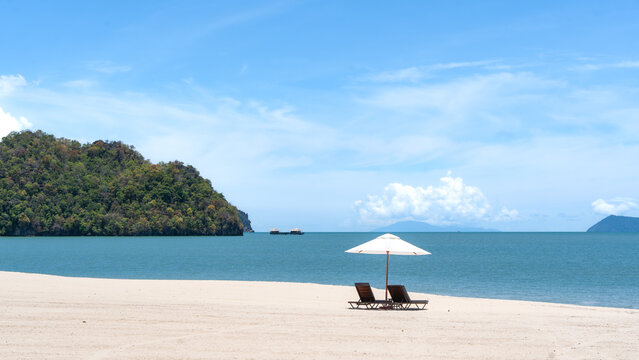 White sand beach with single umbrella and sun loungers at Tanjung Rhu, Langkawi, Malaysia