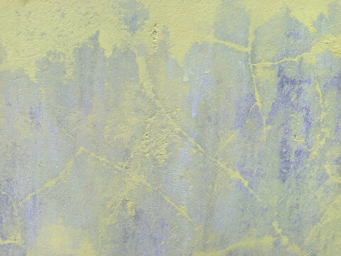 A close-up shot captures the rough, weathered texture of an old concrete wall. The surface is uneven, dark patches, mineral stains, and reflecting natural aging