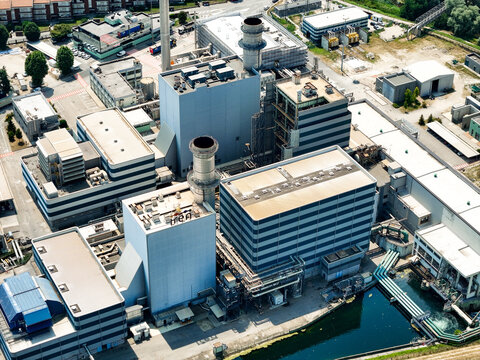 Aerial view of Centrale Termoelettrica - Moncalieri power plant with industrial buildings, cooling towers, and pipes in Moncalieri, Piemonte, Italy.