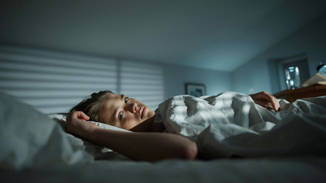 Person lying awake at night unable to sleep, authentic moment of anxiety and overthinking