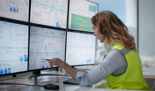 Experienced Engineer Analyzes SCADA Diagrams On Multiple Screens