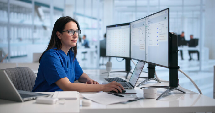 Female Physician Reviews Patient Notes On Laptop