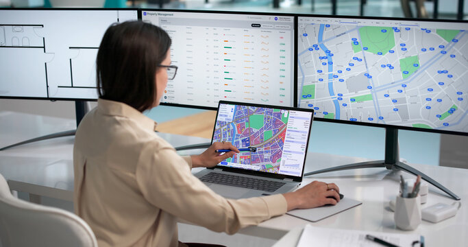 Young Woman Uses Laptop To Study City Land Map