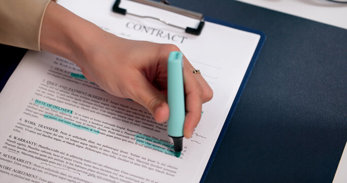 Young Woman In Bright Office Highlighting Important Contract Terms During