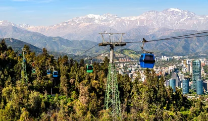 Cable cars of Teleferico Santiago glide over Santiago Metropolitan Park with the Andes mountains and city skyline in the distance. © Leonid Andronov