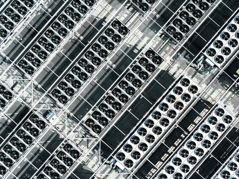 Aerial view of the cooling fan array on the roof of the EU North Riga DC1 data center, featuring rows of industrial ventilation units and metal framework in Riga, Latvia.