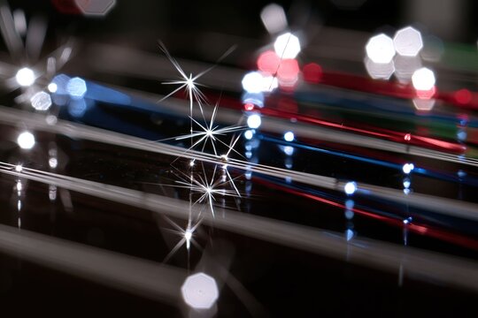Close-up of metal wires with sparkling light reflections and colorful illuminated reflections