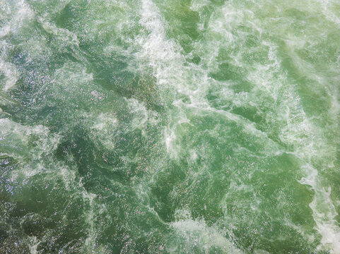 Turbulent Green Water Surface with White Foam