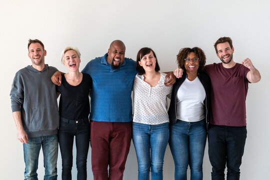 Diverse group of six people smiling and standing together.