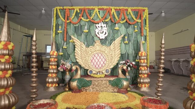Traditional Indian Hindu Wedding Mandap Decoration with Ganesha Idol, Marigold Garlands and Brass Kalash, South India