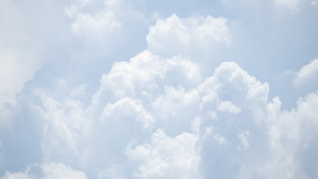 fluffy white clouds building up in the light blue sky