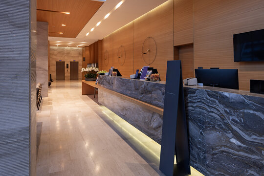 Luxury hotel reception desk with marble counter and wooden wall decor