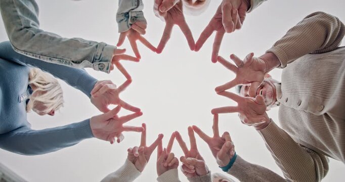 Hand together, smile and star sign with family, gathering and connection for bonding. Low angle, people and huddle at house with shape gesture, solidarity and parental support for weekend break