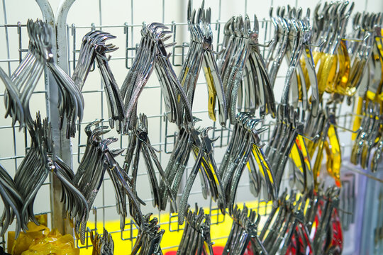Dental pliers displayed in metal rows.