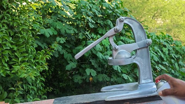 Hand spraying paint onto a heavy duty mechanical juice press