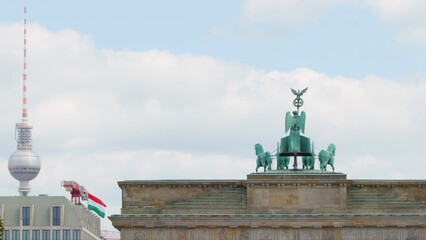 Brandenburg Gate Quadriga Sculpture and Berlin TV Tower Under Cloudy Sky © blueringmedia