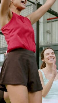 Vertical video: After score red-top woman rising from bleacher pumping fists to friends at court
