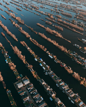 Aerial view of the narrow land strips with houses and boats moored along the canals in Scheendijk, Breukelen, Utrecht, Netherlands.