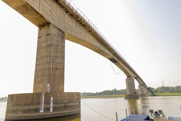 Fototapeta premium Pali Bridge spans the Chambal River during the Palighat Chambal Crocodile Safari, India, offering scenic views of the river and surrounding landscape.