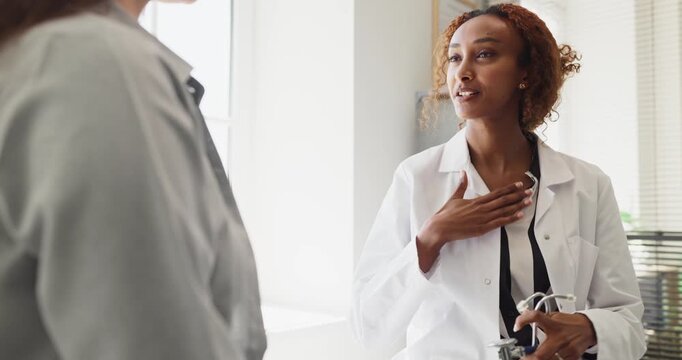 Doctor and patient woman during support consultation. At a clinic a caring doctor explains next steps with empathy during a healthcare appointment and diagnosis. Kind care builds patient trust.