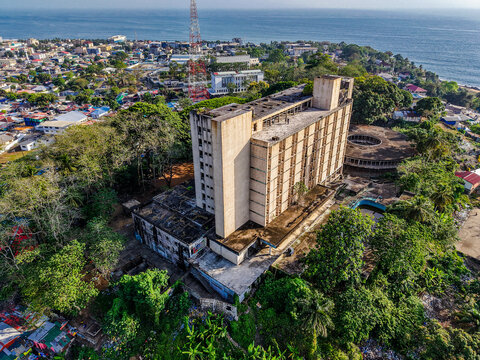 Aerial view of the abandoned Ducor Hotel surrounded by lush vegetation and overlooking the Atlantic Ocean in Monrovia, Liberia.